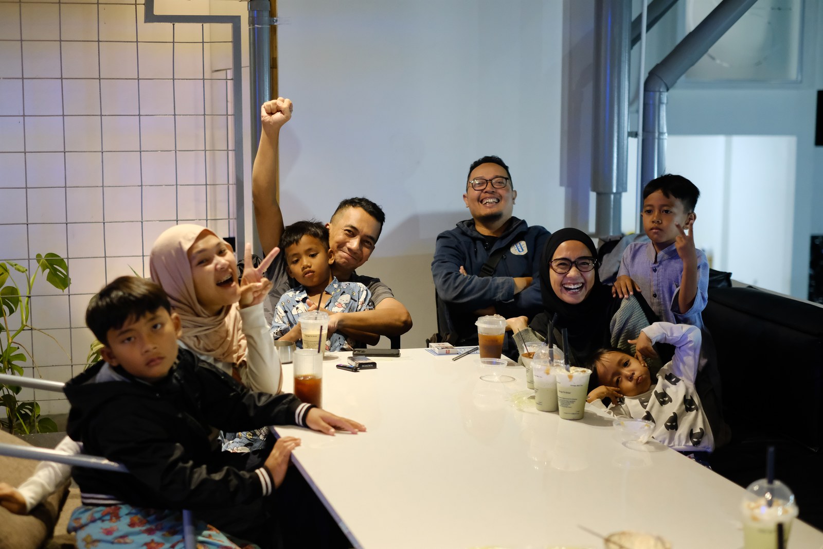Keluarga dengan anak-anak berkumpul di meja panjang dalam ruang Erion.