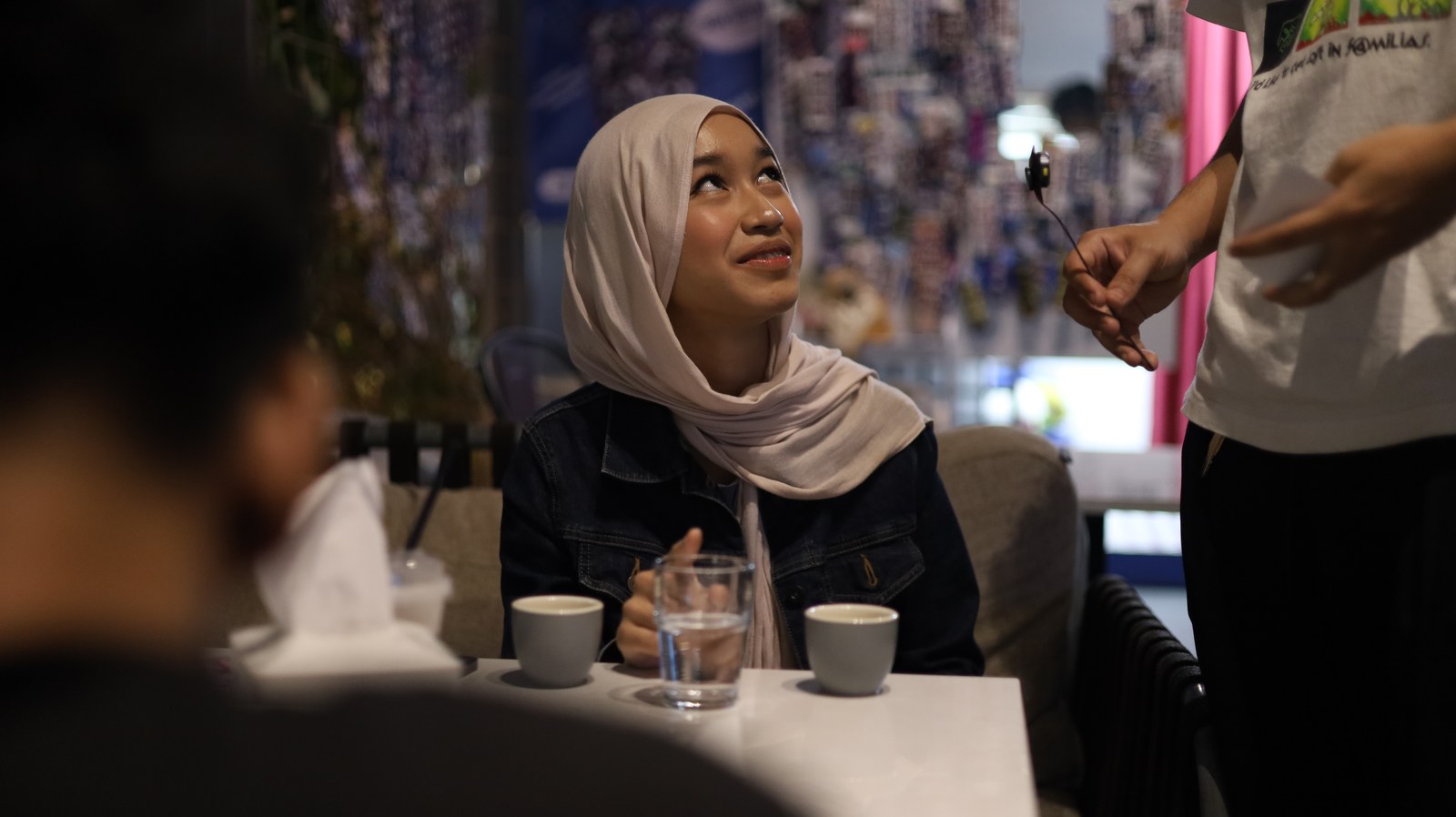 Pengunjung berbincang di meja saat menikmati kopi.