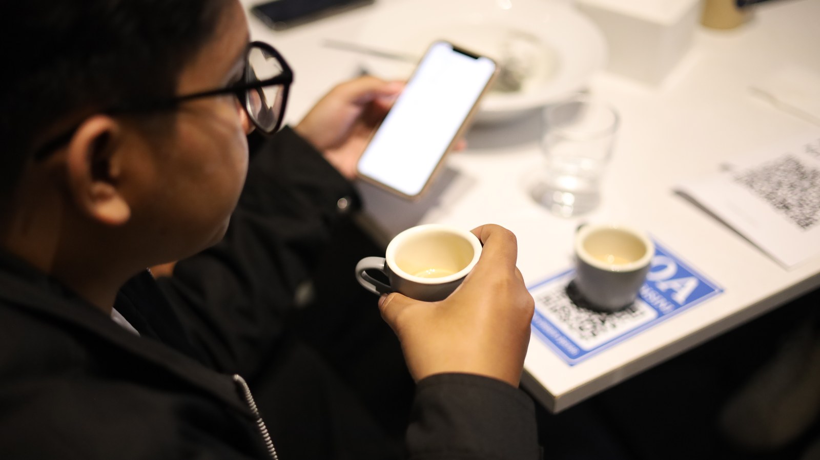 Pengunjung memegang secangkir kopi di meja Erion.