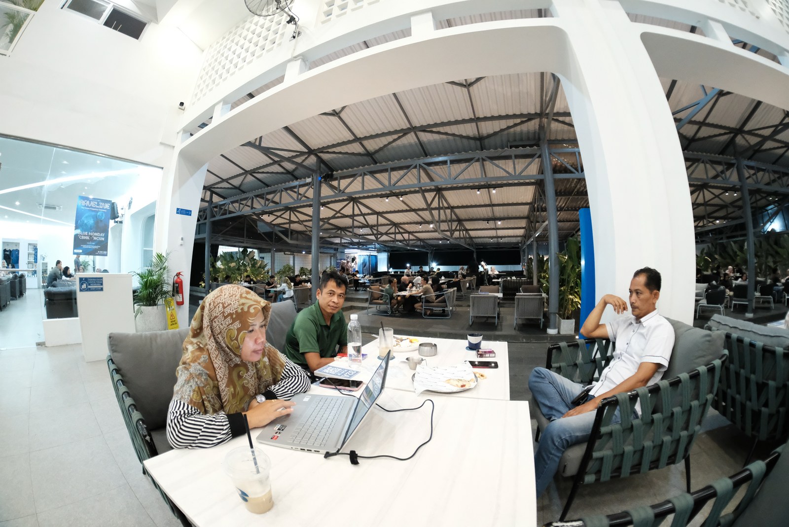 Pengunjung duduk bersama di meja Erion, dengan area indoor dan teras di belakangnya.